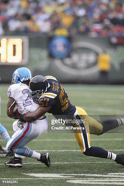 Linebacker Bart Scott of the New York Jets stops Running Back Chris Johnson of the Tennessee Titans at Giants Stadium on September 27, 2009 in East...