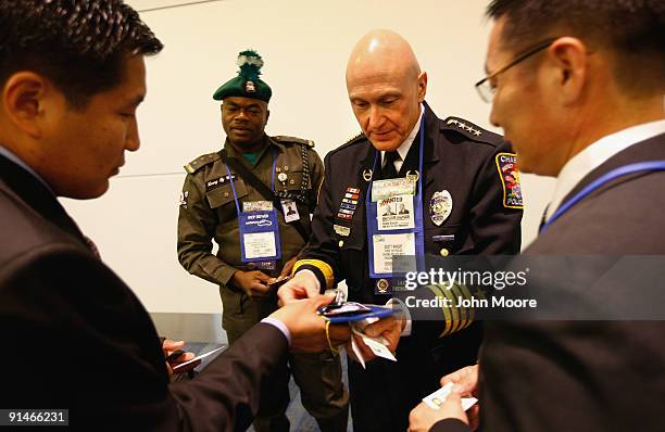 Scott Knight, police chief in Chaska, MN, exchanges business cards with international law enforcement officials at a conference of the International...