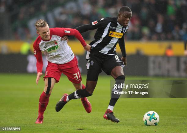 Philipp Max of Augsburg and Denis Zakaria of Moenchengladbach battle for the ball during the Bundesliga match between Borussia Moenchengladbach and...