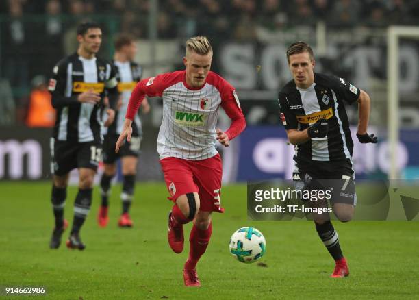 Patrick Herrmann of Moenchengladbach and Philipp Max of Augsburg battle for the ball during the Bundesliga match between Borussia Moenchengladbach...