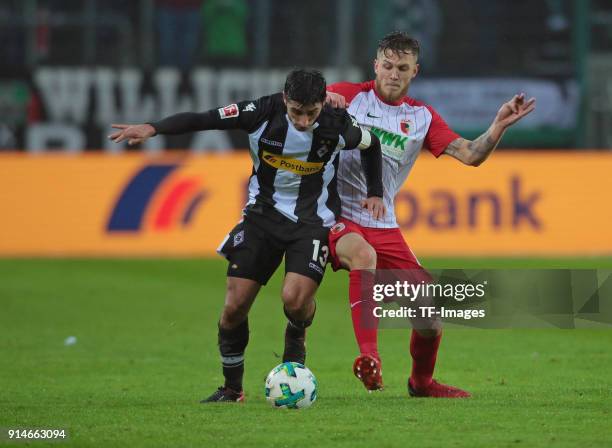 Lars Stindl of Moenchengladbach and Jeffrey Gouweleeuw of Augsburg battle for the ball during the Bundesliga match between Borussia Moenchengladbach...