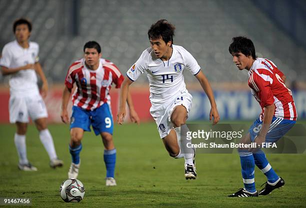 Ki Han Moon of Korea Republic breaks away from Hernan Perez and Robin Ramirez of Paraguay during the FIFA U20 World Cup Round of 16 match between...