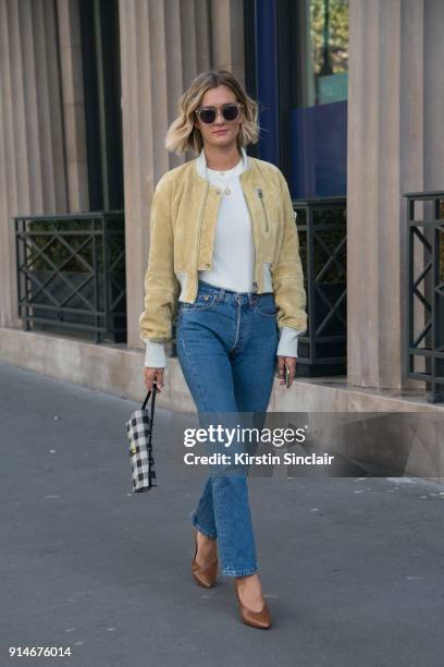 Fashion blogger Adenorah, Anne-Laure Mais wears an Acne jacket, top and shoes, Levi"u2019s jeans, Mansur Gavriel bag and vintage sunglasses day 5 of...