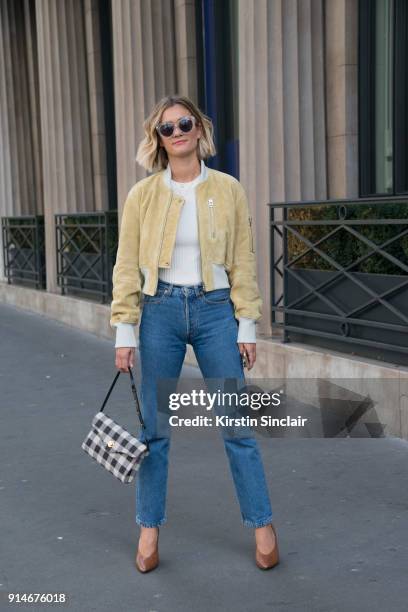 Fashion blogger Adenorah, Anne-Laure Mais wears an Acne jacket, top and shoes, Levi"u2019s jeans, Mansur Gavriel bag and vintage sunglasses day 5 of...