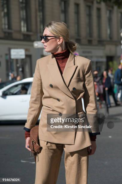 Fashion blogger Camille Charriere wears an Acne polo neck sweater, Victoria Beckham suit, Nanushka bag and Le Specs sunglasses day 5 of Paris Womens...