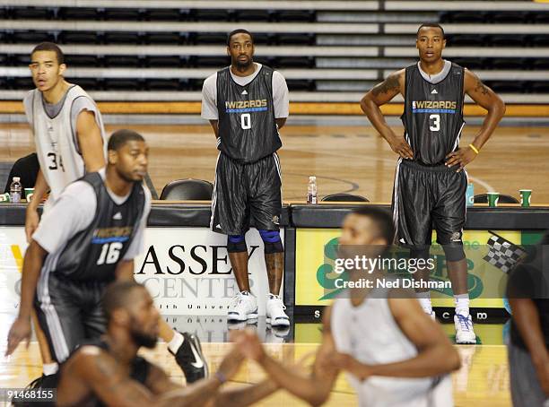 Gilbert Arenas and Caron Butler of the Washington Wizards watch practice during the 2009 NBA Training Camp at the Siegel Center on the campus of...