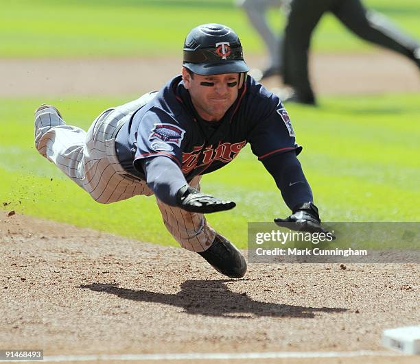 Nick Punto of the Minnesota Twins dives head-first into third base against the Detroit Tigers during the game at Comerica Park on October 1, 2009 in...