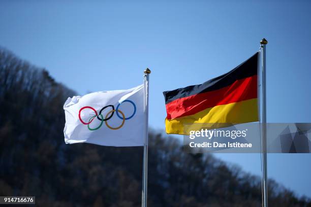 The German national flag flaps in the wind next to the Olympic flag during the Germany team's flag raising ceremony during previews ahead of the...