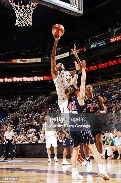 DeWanna Bonner of the Phoenix Mercury goes up for a shot against Tully Bevilaqua and Tammy Sutton-Brown of the Indiana Fever in Game one of the WNBA...