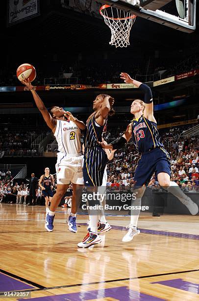 Temeka Johnson of the Phoenix Mercury goes up for a shot against Tamika Catchings and Katie Douglas of the Indiana Fever in Game one of the WNBA...