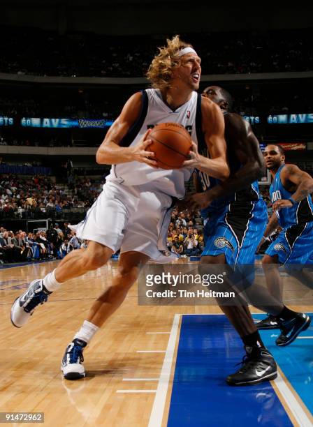 Dirk Nowitzki of the Dallas Mavericks spins to the baseline against Brandon Bass of the Orlando Magic in preseason action at the American Airlines...