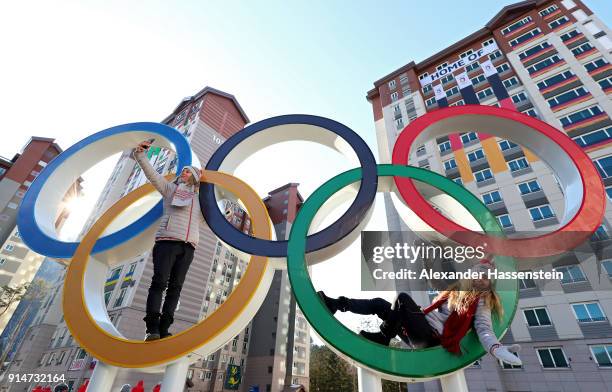 Ski coaches Kjersti Ostgaard Buaas and Chanelle Sladics of Team Slovakia pose on the Olympic Rings in the Athletes' Village during previews ahead of...