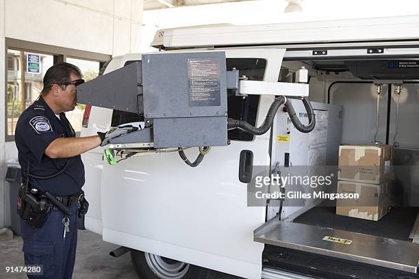Looking for hidden weapons and ammunitions, a Homeland Security agents scans a box from a southbound vehicule on the Lincoln-Juarez Bridge separating...