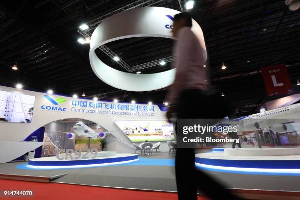 Visitor walks past the Commercial Aircraft Corp. Of China Ltd. Booth at the Singapore Airshow held at the Changi Exhibition Centre in Singapore, on...