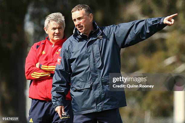 Neil Craig the coach of the Adelaide Crows AFL football team looks on as Ernie Merrick the coach of the Victory gives instructions during a Melbourne...