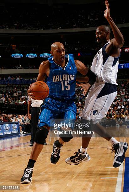 Vince Carter of the Orlando Magic drives against Quinton Ross of the Dallas Mavericks in preseason action at the American Airlines Center on October...