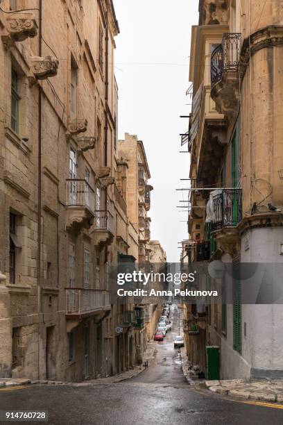 wet narrow street in historical city of valletta,malta - anna pekunova stock-fotos und bilder