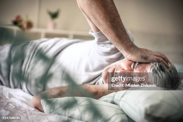 pijn in hoofd. - man sleeping on bed stockfoto's en -beelden