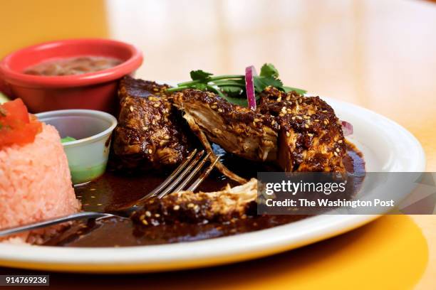 Mole Poblano - chicken in dark red mole sauce. Includes, rices, beans, salad and tortillas photographed in Washington, DC. .