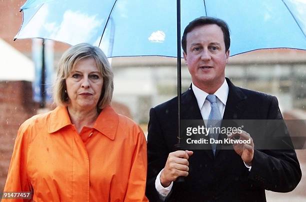 Conservative leader David Cameron and Shadow Secretary of State for Work and Pensions Theresa May walk through the rain on the second day of the...