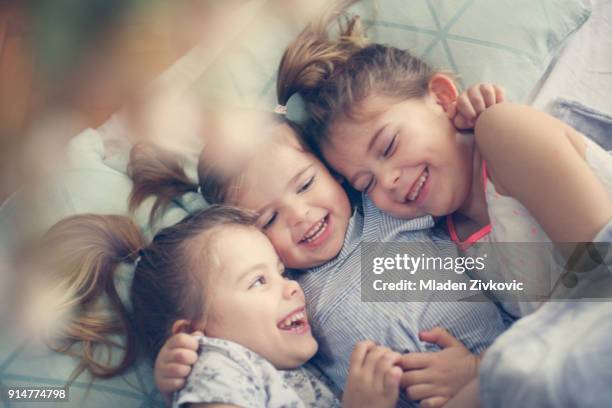 happy little girls in bed. - children only stock pictures, royalty-free photos & images