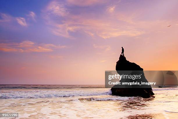 ocean sky sunset and man on top of rock formation - malibu beach stockfoto's en -beelden