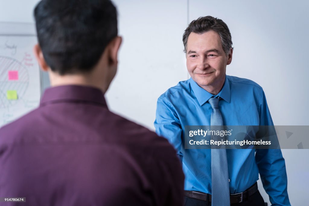 Two businessmen greeting one another with a handshake