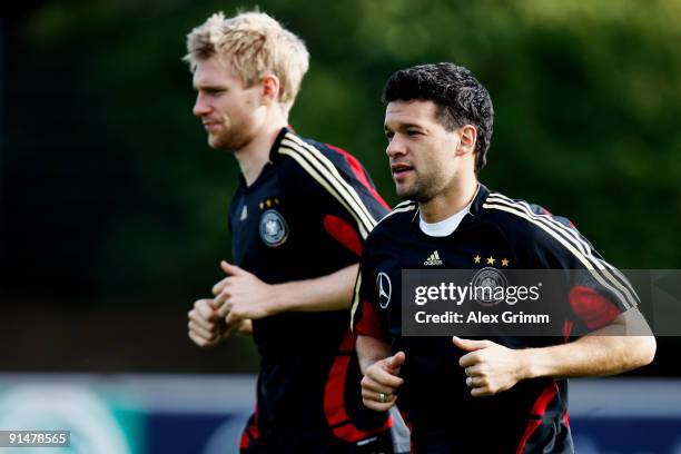 Per Mertesacker and Michael Ballack warm up during a training session of the German national football team at the Bruchweg stadium training ground on...
