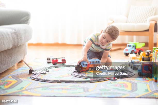 little boy, 3-4 years, playing with train and toys at home - train toy track stockfoto's en -beelden