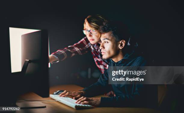 two young people working on a pc late at night - staring at screen stock pictures, royalty-free photos & images