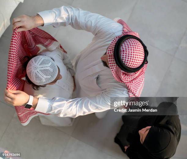 helping son to wear clothes - riyadh stock pictures, royalty-free photos & images