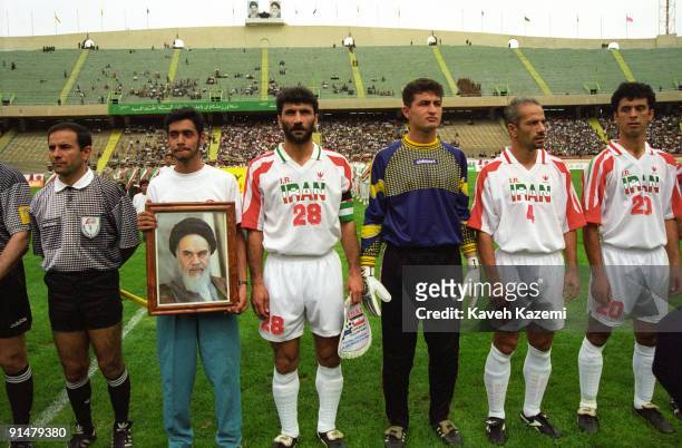 Team member of the Iran national football team holds a portrait of Ayatollah Khomeini during a match against a foreign team at Azadi Stadium, Tehran,...