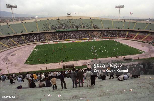 The Iran national football team plays against a foreign team at Azadi Stadium in west Tehran, July 1998. Portraits of Ayatollah Khomeini and Khamenei...