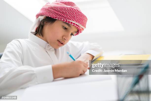 arabic teenage boy doing homework - saudi youth stock-fotos und bilder