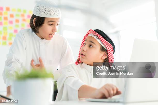 middle eastern students learning computer programming on laptops - arabic keyboard fotografías e imágenes de stock