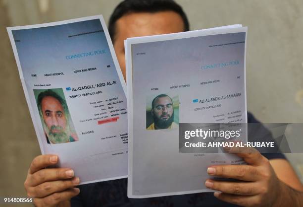 An Iraqi man holds printed profiles of Abu Bakr al-Baghdadi an his deputy Abd al-Rahman al-Qaduli released by Iraqi authorities on February 6, 2018....