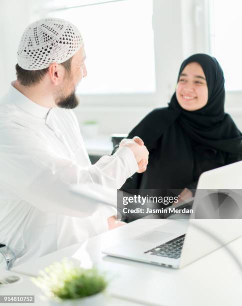 arabic business male and female closing the deal with handshaking - business hand shake with arabs stock pictures, royalty-free photos & images