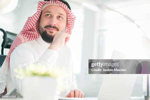 middle eastern man using computer for professional work - saudi home stock pictures, royalty-free photos & images