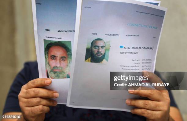 An Iraqi man holds printed profiles of Abu Bakr al-Baghdadi an his deputy Abd al-Rahman al-Qaduli released by Iraqi authorities on February 6, 2018...