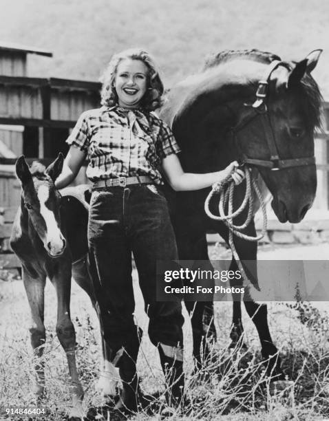 American actress and singer Priscilla Lane with two horses on a ranch in California, circa 1939. She has just completed work on the film 'Dust Be My...