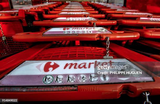 The logo of French retail giant Carrefour is seen on shopping trolleys in a "Carrefour market" supermarket on February 6, 2018 in Vieux-Berquin,...