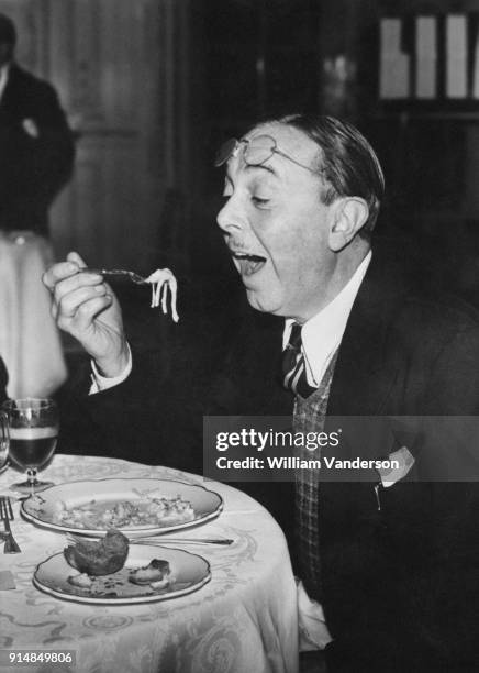 English actor and comedian Lupino Lane eating spaghetti during a Leichner luncheon at the Savoy Hotel in London, 30th October 1945.