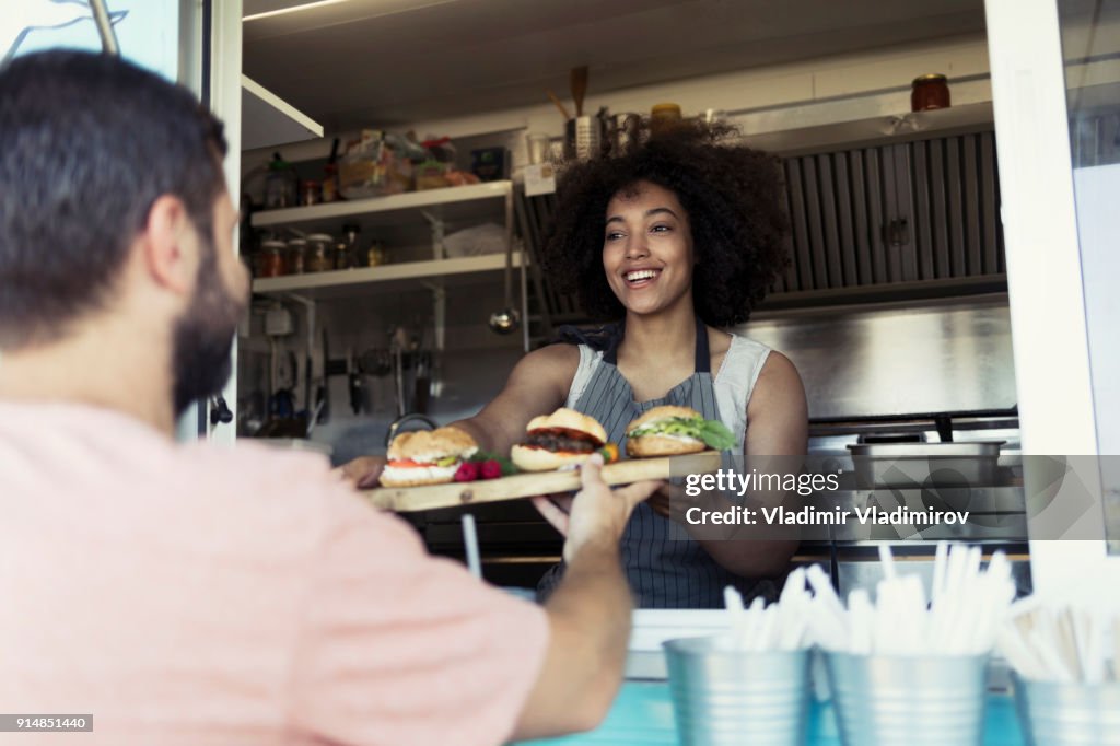 Food van worker giving order to customer