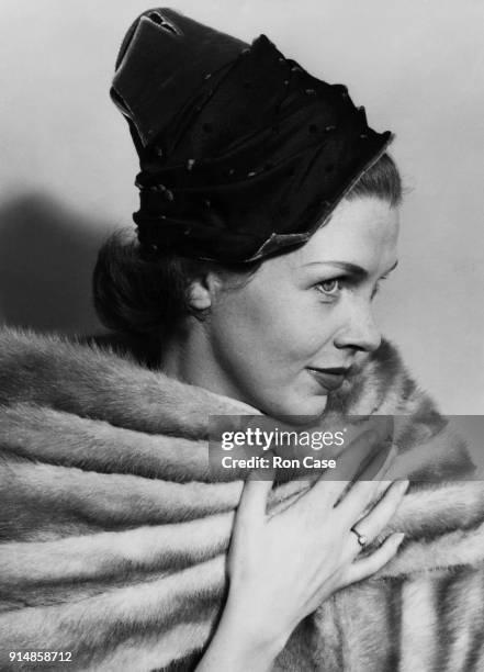 Actress Sarah Lawson models 'Everest Line', a black taffeta hat with pink and red velvet spots by Dolores of London, 1st September 1953.