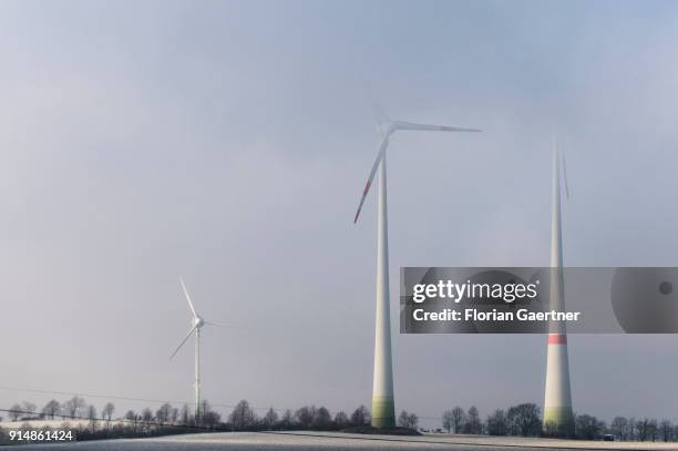 Three wind turbines in the fog are pictured on February 05, 2018 in Loebau, Germany.