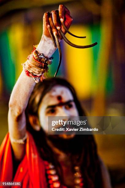 Sadhu displaying his very long fingernails with hand raised during the Maha Kumbh Mela on February 6th, 2013 at Allahabad, Uttar Pradesh, India