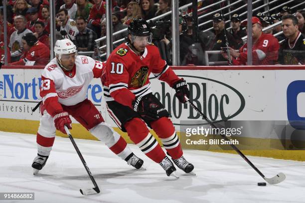 Patrick Sharp of the Chicago Blackhawks grabs the puck ahead of Trevor Daley of the Detroit Red Wings in the first period at the United Center on...