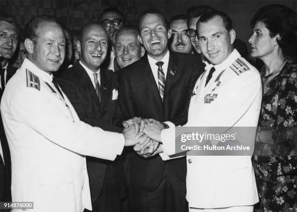 Russian cosmonauts and American astronauts join hands at a hotel in Athens, Greece, September 1965. From left to right, Alexey Leonov, Charles Conrad...