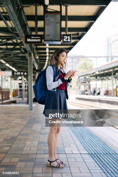 looking at train timetable on smart phone - skinny nerd stock pictures, royalty-free photos & images