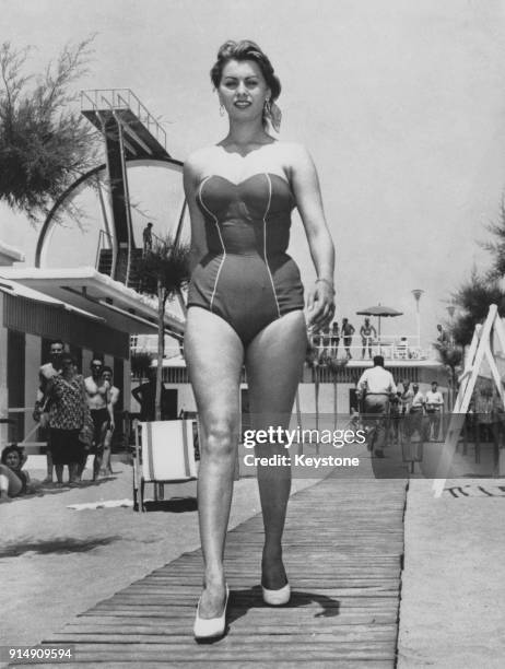 Italian actress Sophia Loren wearing a one-piece swimsuit to the beach, circa 1956.